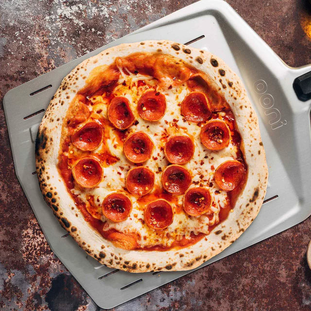 Pizzaschaufel Ooni Pizza Peel mit Salamipizza
