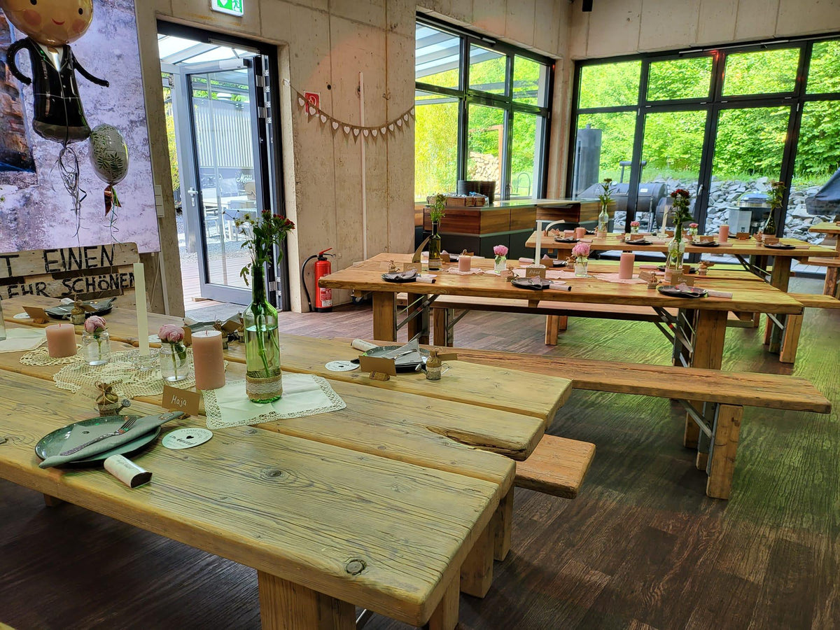Grillgoods Eventlocation mit eingedeckten Holztischen