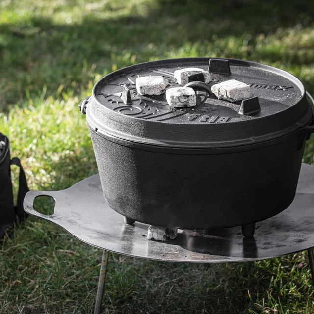 ein ft18 Dutch Oven von Petromax mit heißen Briketts auf einer Feuerschale